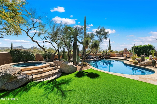 view of swimming pool featuring an in ground hot tub, a mountain view, and a lawn