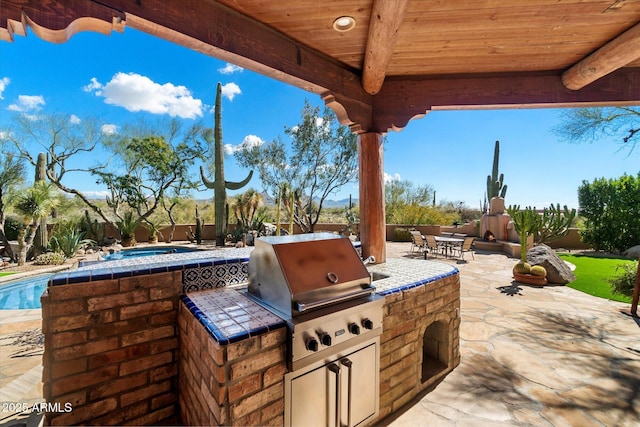 view of patio / terrace featuring an outdoor kitchen and a grill