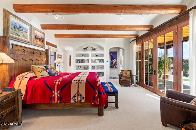 bedroom featuring multiple windows, beam ceiling, carpet, and access to outside