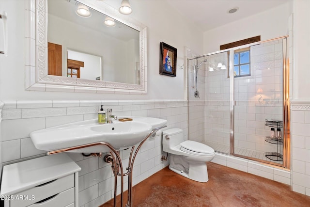 bathroom featuring toilet, an enclosed shower, sink, and tile walls