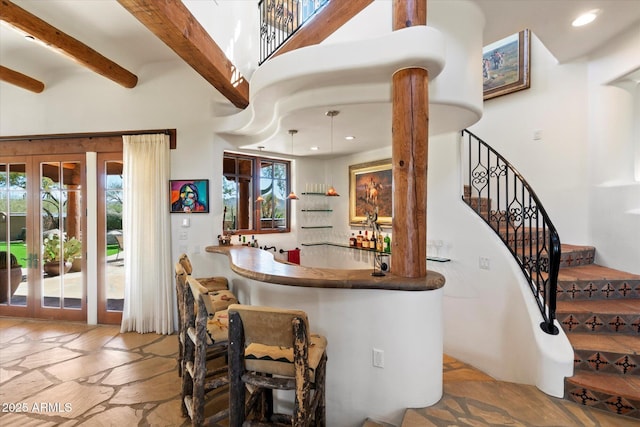 bar featuring beam ceiling and french doors