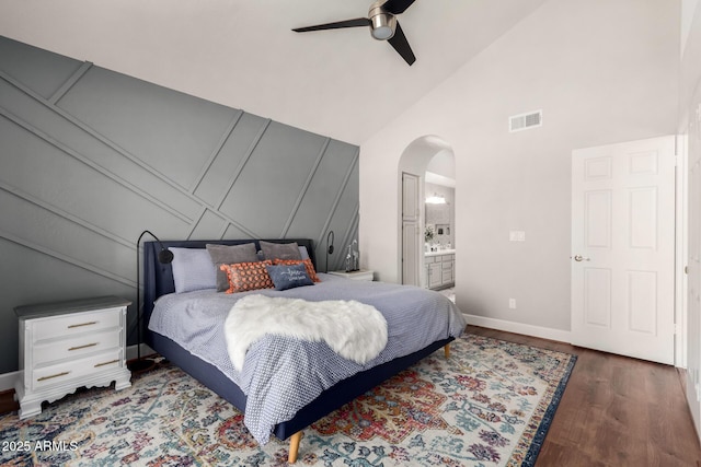bedroom featuring visible vents, high vaulted ceiling, wood finished floors, arched walkways, and baseboards