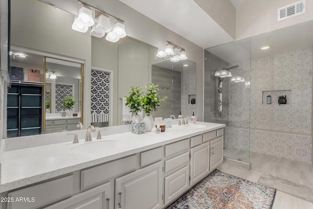 bathroom featuring double vanity, visible vents, and a sink