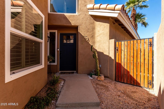 property entrance featuring stucco siding and a gate