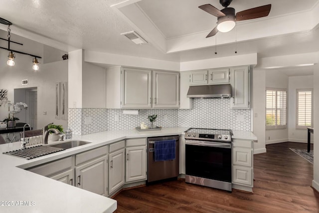 kitchen featuring dark wood finished floors, ceiling fan, light countertops, under cabinet range hood, and appliances with stainless steel finishes