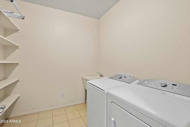 laundry area with sink, washer and clothes dryer, and light tile patterned flooring