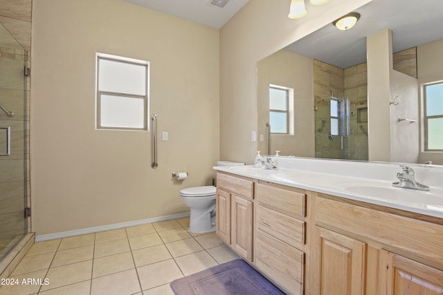 bathroom with tile patterned floors, vanity, toilet, and a shower with shower door