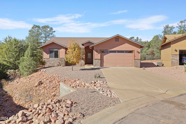 single story home with a garage and central air condition unit