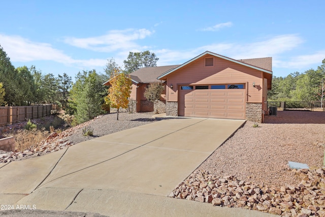 single story home featuring a garage and central AC unit