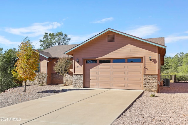 ranch-style house with a garage and cooling unit