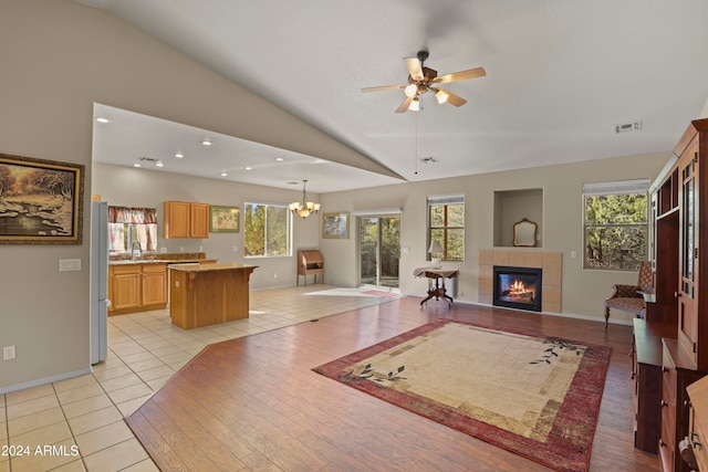 living room with light tile patterned floors, vaulted ceiling, and plenty of natural light