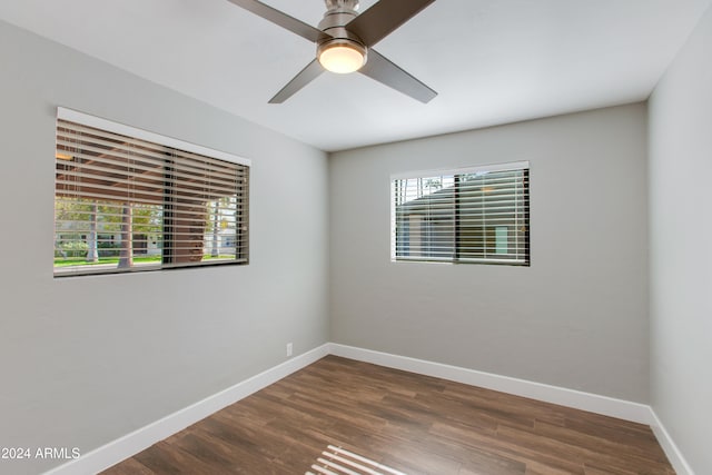 unfurnished room with dark wood-type flooring, ceiling fan, and plenty of natural light