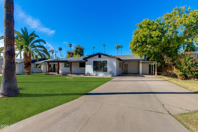 single story home with a front yard and a carport