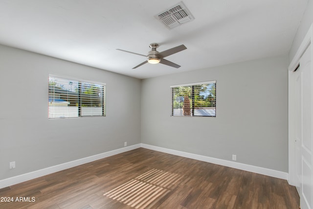 empty room with dark hardwood / wood-style flooring and ceiling fan