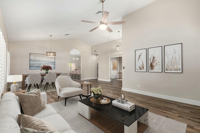 living area with wood finished floors, visible vents, baseboards, ceiling fan, and vaulted ceiling