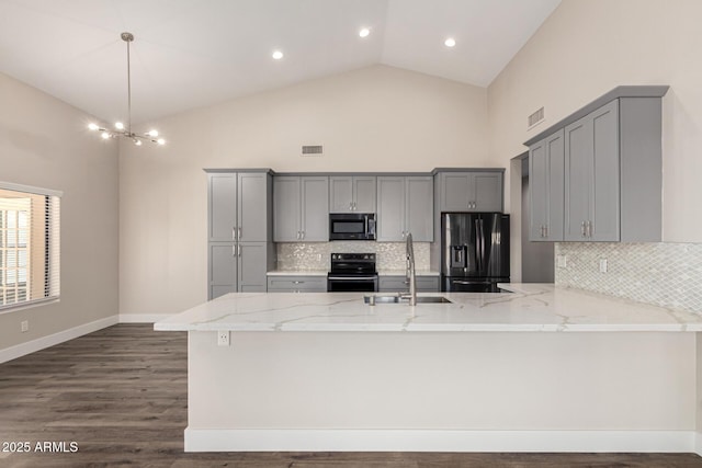 kitchen featuring light stone countertops, a peninsula, gray cabinets, stainless steel range with electric stovetop, and black refrigerator with ice dispenser