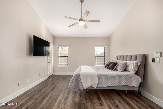 bedroom with vaulted ceiling, wood finished floors, and baseboards