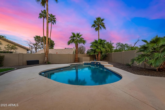 pool at dusk with a patio area, a fenced in pool, and a fenced backyard