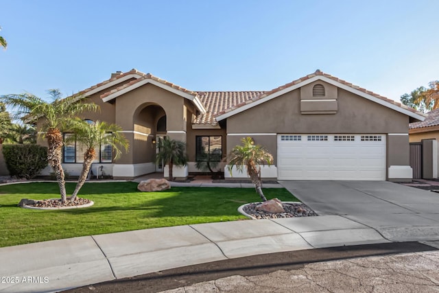 mediterranean / spanish home with a front yard, stucco siding, concrete driveway, a garage, and a tiled roof