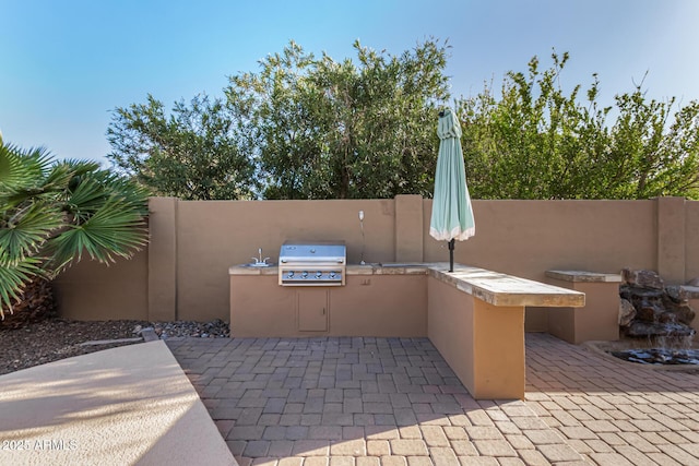 view of patio / terrace with area for grilling, a grill, and fence