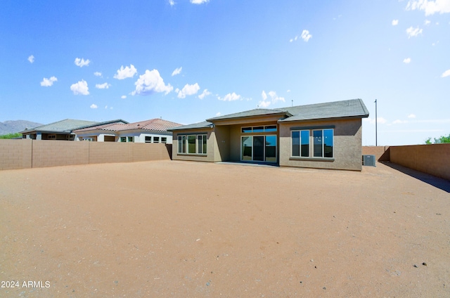 rear view of property with a fenced backyard and stucco siding