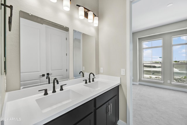 full bathroom featuring a sink, baseboards, and double vanity