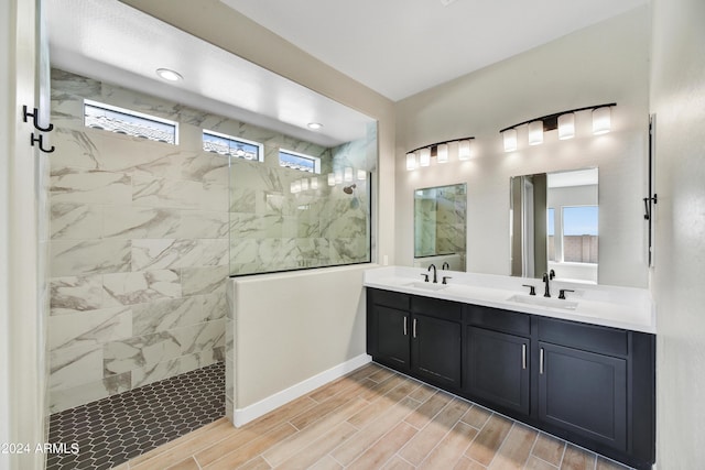 bathroom with a walk in shower, double vanity, a sink, and wood tiled floor