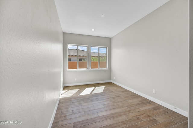 spare room featuring baseboards and wood finished floors