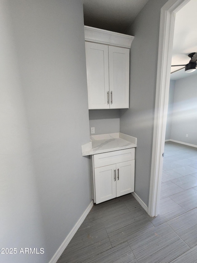 interior space with light stone countertops and white cabinets