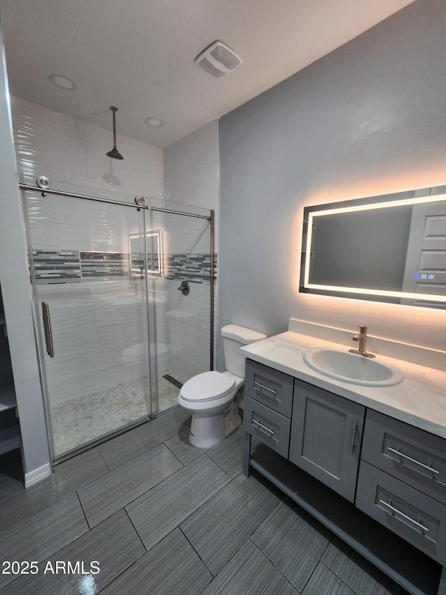 bathroom featuring vanity, toilet, and walk in shower