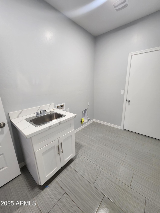 clothes washing area featuring washer hookup, sink, and cabinets