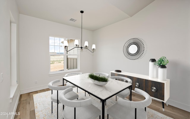 dining area featuring light wood-type flooring and an inviting chandelier