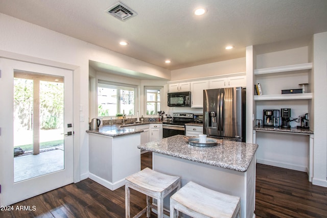 kitchen with appliances with stainless steel finishes, white cabinets, and light stone counters