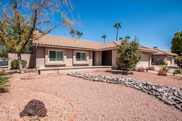 ranch-style house with stucco siding, a tiled roof, and a garage