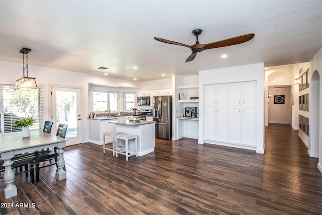 kitchen with a kitchen island, stainless steel appliances, dark hardwood / wood-style flooring, and white cabinetry