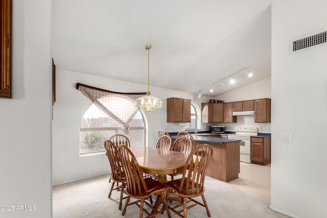 dining space featuring visible vents, vaulted ceiling, track lighting, light carpet, and a chandelier