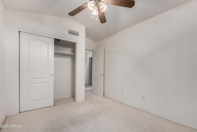 unfurnished bedroom featuring visible vents, a closet, carpet, ceiling fan, and vaulted ceiling