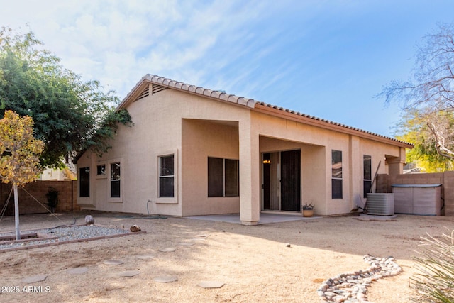 back of house with central AC unit, a patio area, fence, and stucco siding