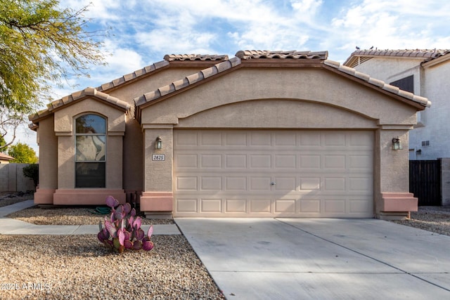 mediterranean / spanish home with stucco siding, a garage, and concrete driveway