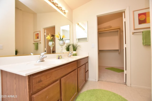 full bath with tile patterned flooring, double vanity, baseboards, and a sink