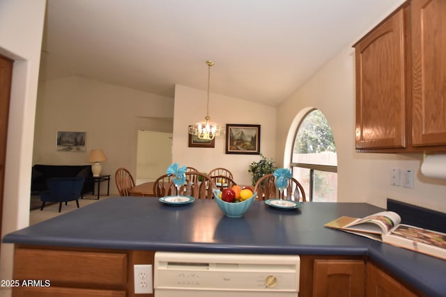 kitchen with dark countertops, a peninsula, brown cabinetry, lofted ceiling, and dishwasher