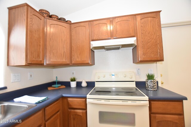 kitchen featuring a sink, dark countertops, under cabinet range hood, and white range with electric cooktop