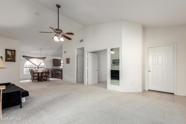 unfurnished living room with visible vents, high vaulted ceiling, ceiling fan, and carpet flooring