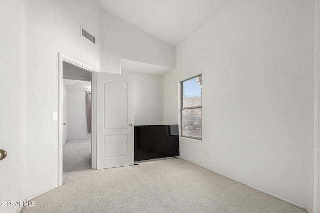 spare room with visible vents, carpet flooring, and high vaulted ceiling