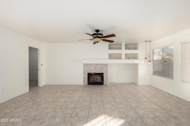 unfurnished living room with a tile fireplace, baseboards, light tile patterned flooring, and ceiling fan