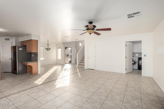 unfurnished living room featuring washer / clothes dryer, a ceiling fan, visible vents, and stairs