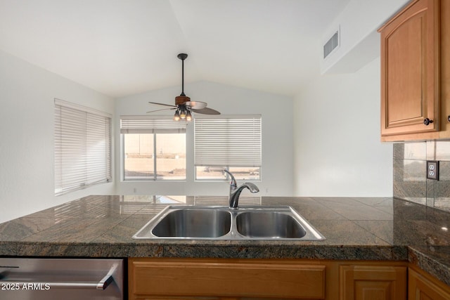 kitchen with vaulted ceiling, dishwasher, ceiling fan, tile countertops, and a sink