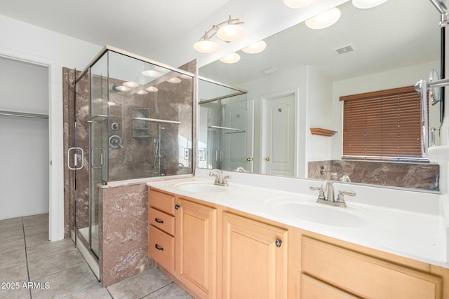 bathroom with a sink, visible vents, a shower stall, and double vanity