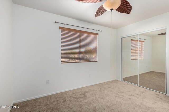 unfurnished bedroom with carpet floors, baseboards, a ceiling fan, and a closet