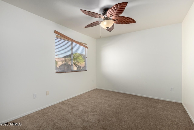 carpeted empty room featuring ceiling fan and baseboards
